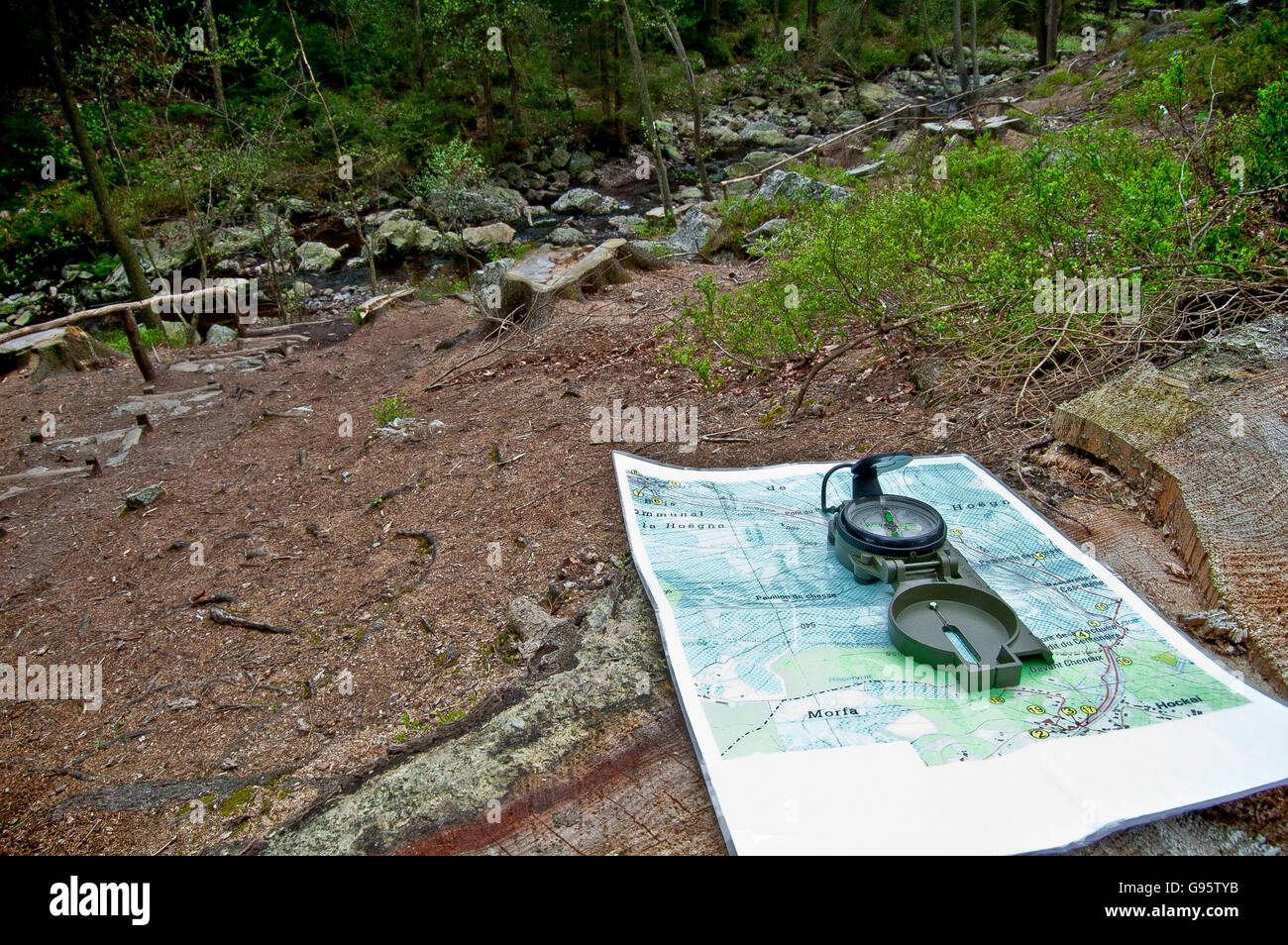 Map and compass next to an Ardennes river Stock Photo
