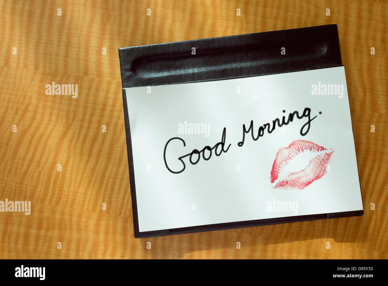 Sexy girl Red lips kiss Love you word write on white note paper on bed stand table in the morning light. romantic message Stock Photo