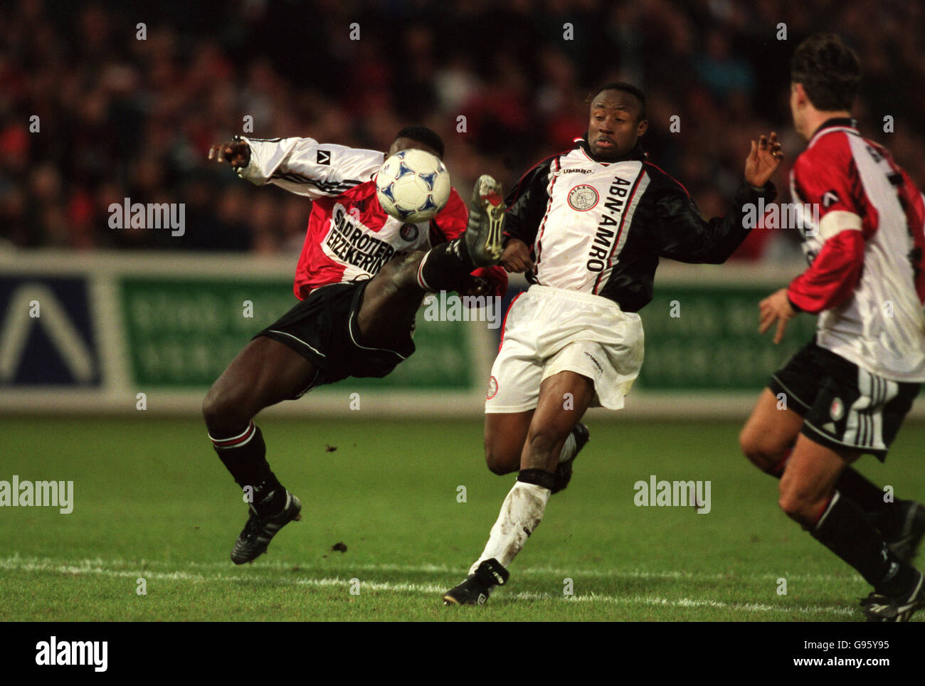 Feyenoord's Christian Gyan (left) tries to head clear from Ajax's Tijani Babangida (centre) Stock Photo