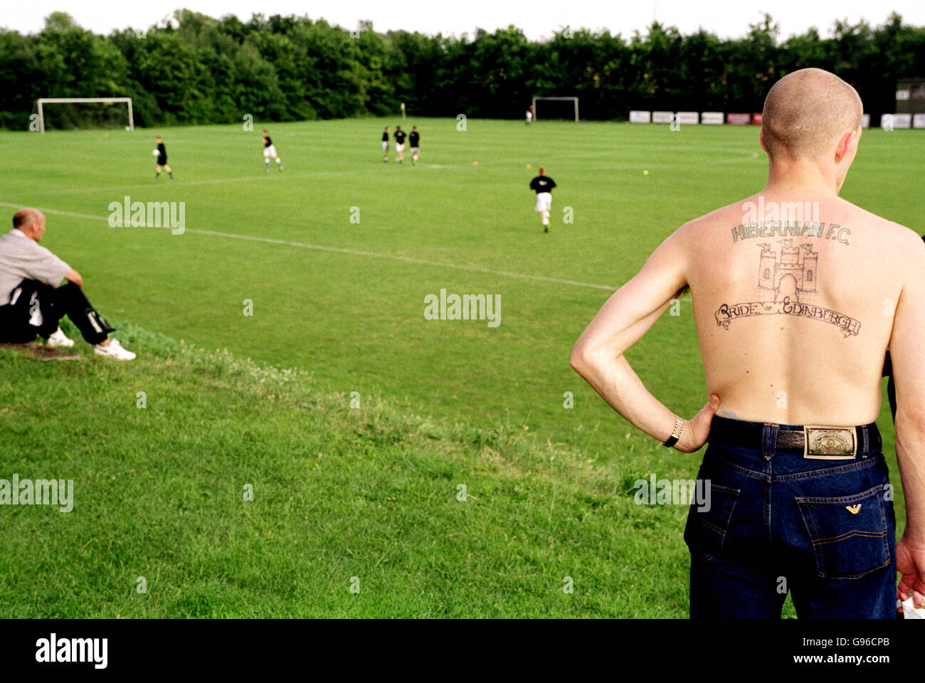 A Hibernian fan with a tattoo on his back reading 'Hibernian - Pride of Edinburgh' Stock Photo