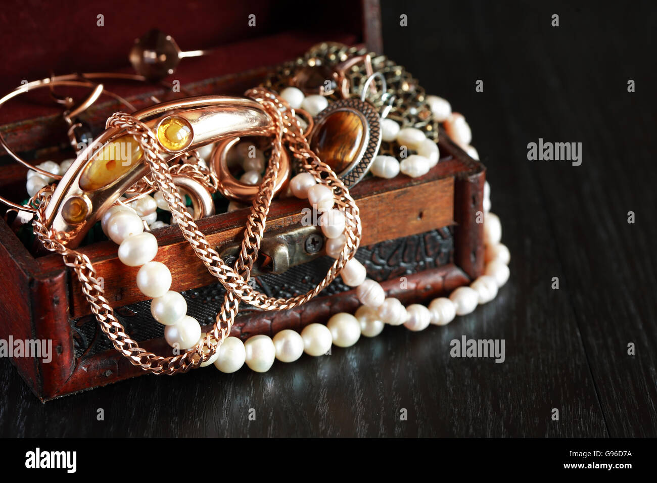 Nice vintage open box full of various jewelry on dark wooden background
