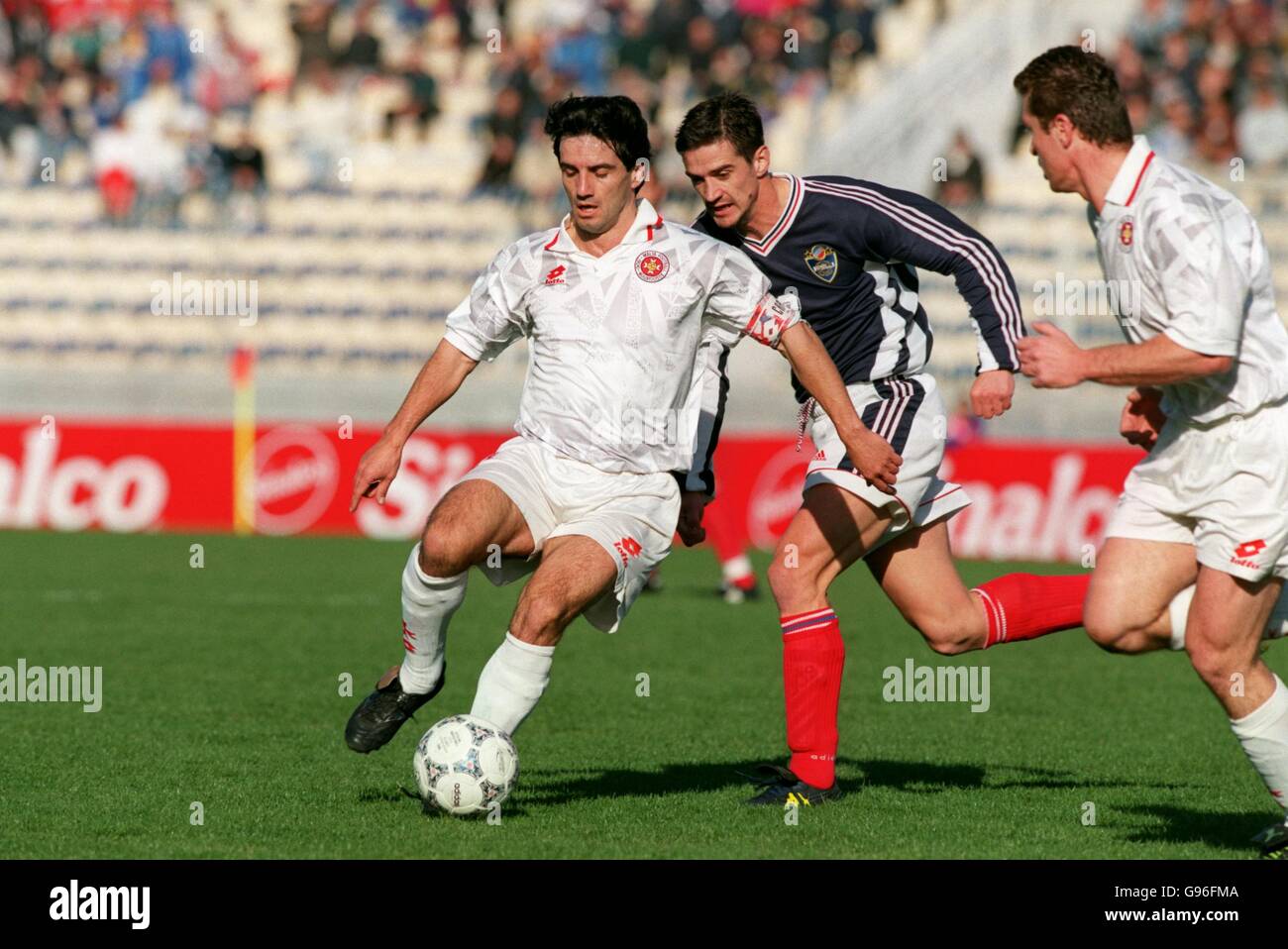 Malta's Carmel Busuttil (left) shields the ball from Yugoslavia's Zoran Mirkovic (centre) Stock Photo