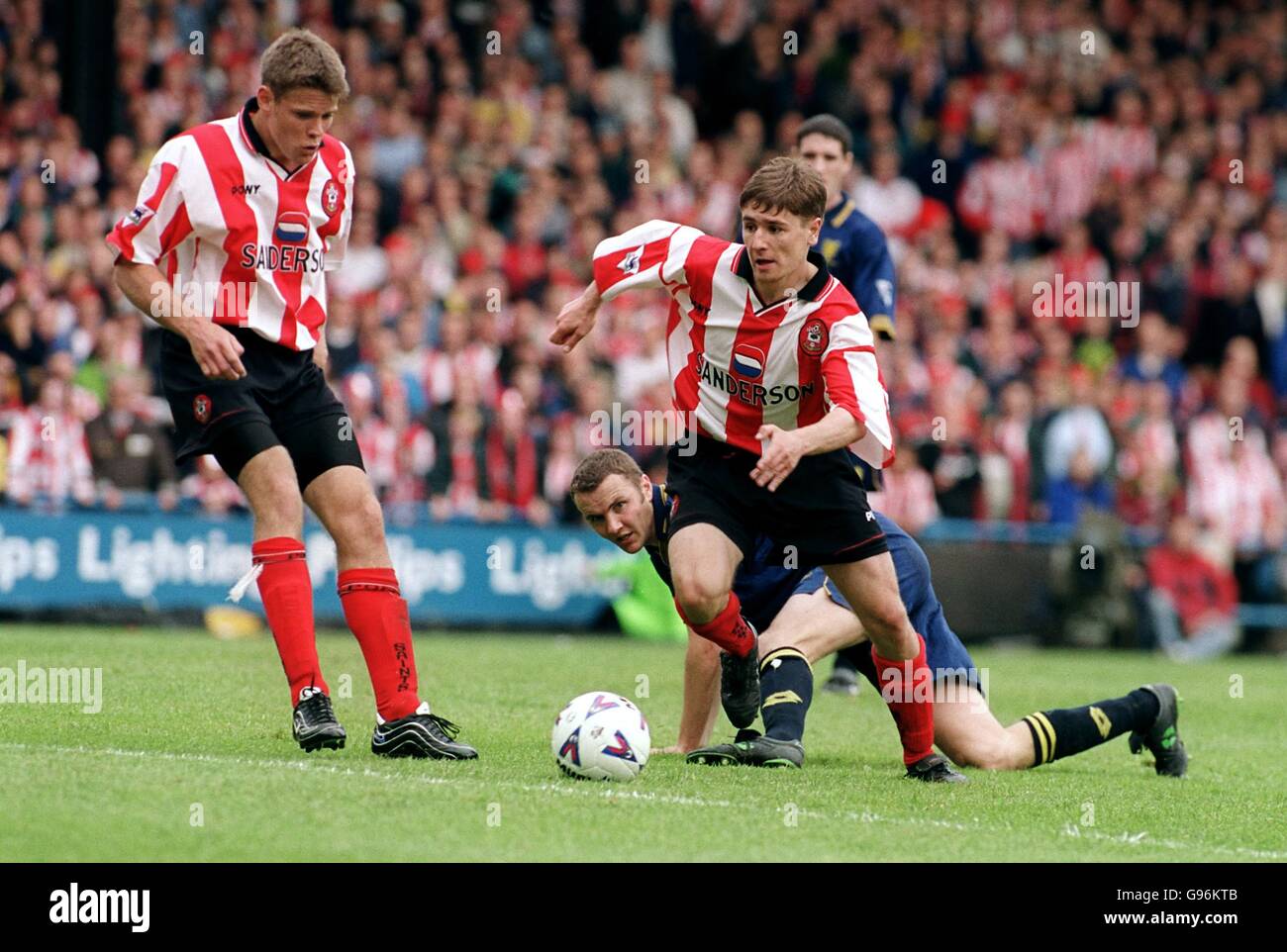 Southampton's Marians Pahars (right) gets away from Wimbledon's Dean Blackwell (on floor) as teammate James Beattie (left) looks on Stock Photo