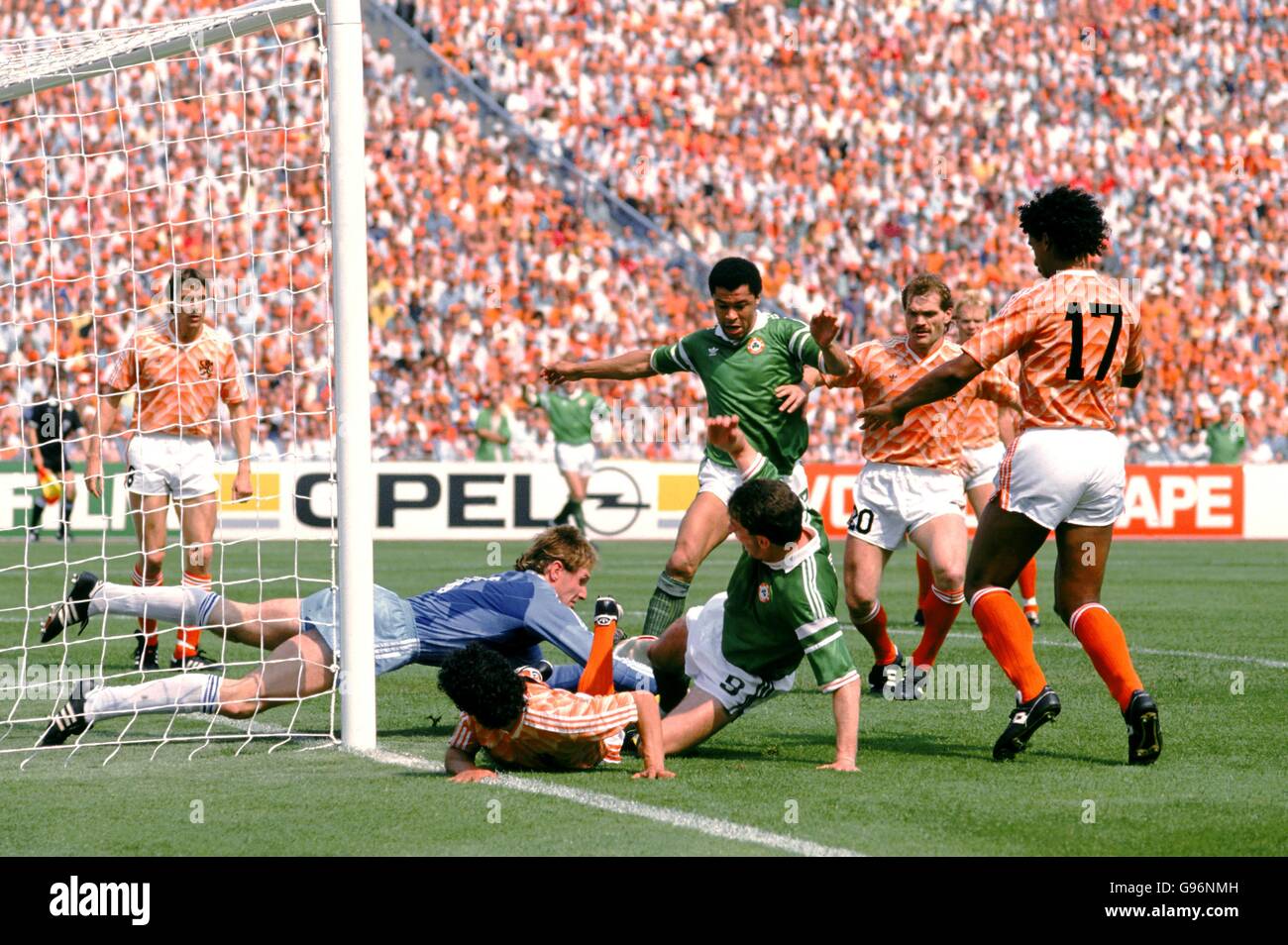 Holland goalkeeper Hans Van Breukelen (second left) dives to save at the feet of Ireland's Paul McGrath (centre) and John Aldridge (third right), watched by teammates Arnold Muhren (left), Jan Wouters (second right) and Frank Rijkaard (right) Stock Photo