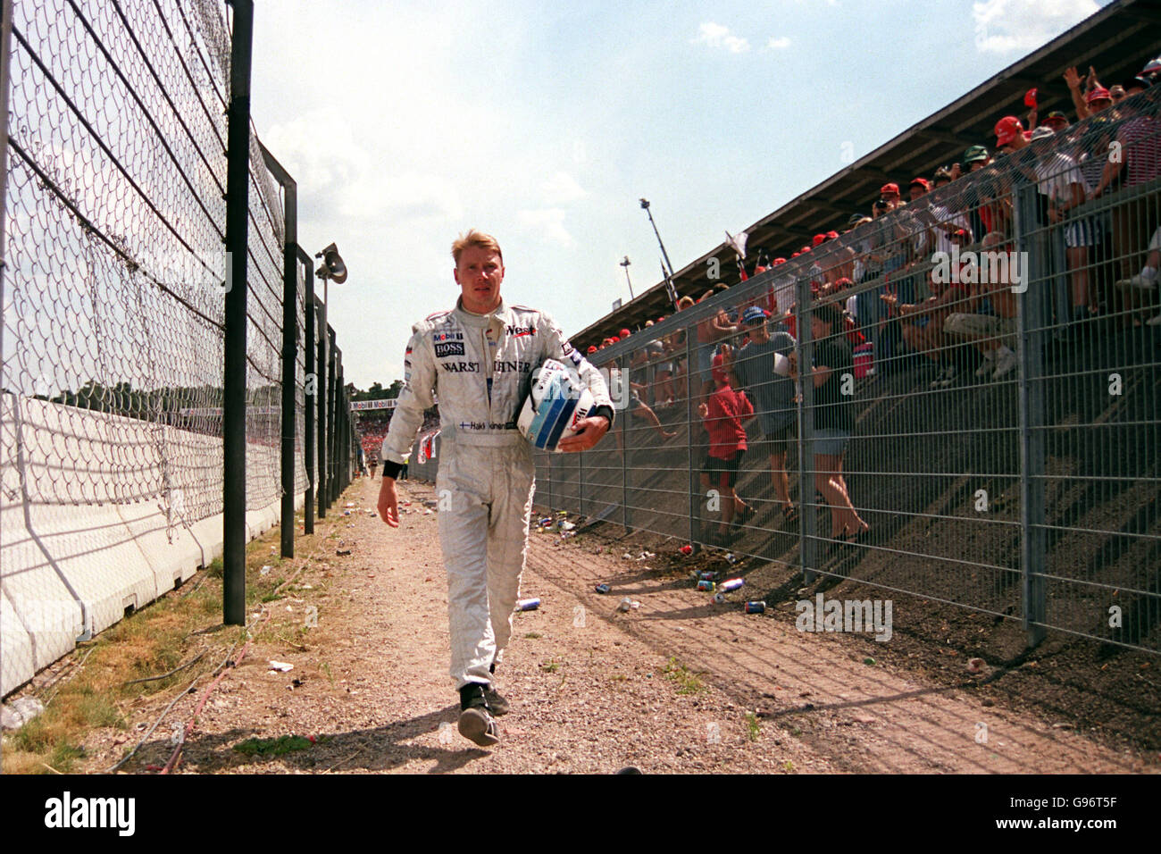 Mika hakkinen walks back to pits after his crash hi-res stock
