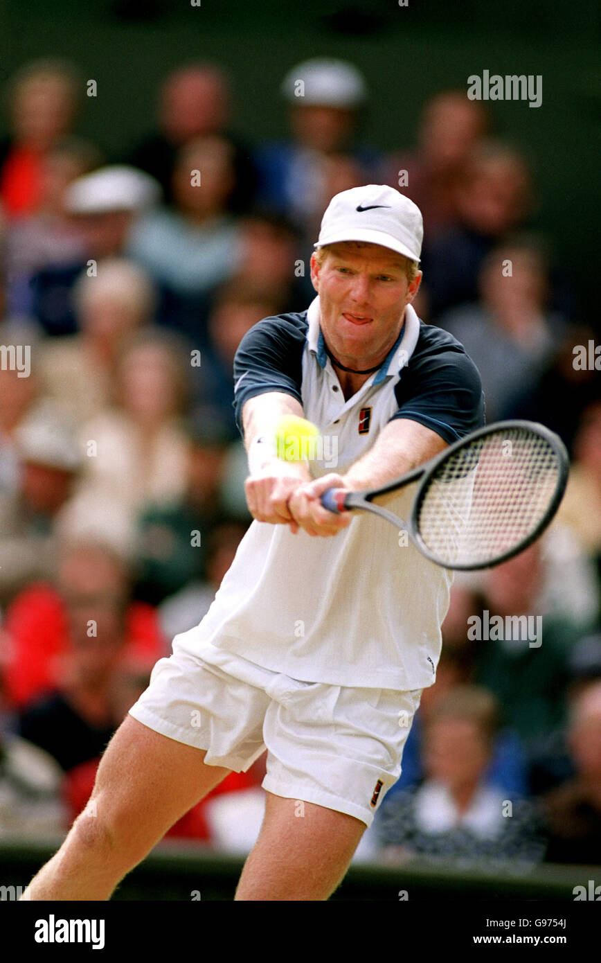 Tennis - Wimbledon, Mens Singles .Tim Henman v Jim Courier. Jim Courier lunges for a backhand Stock Photo