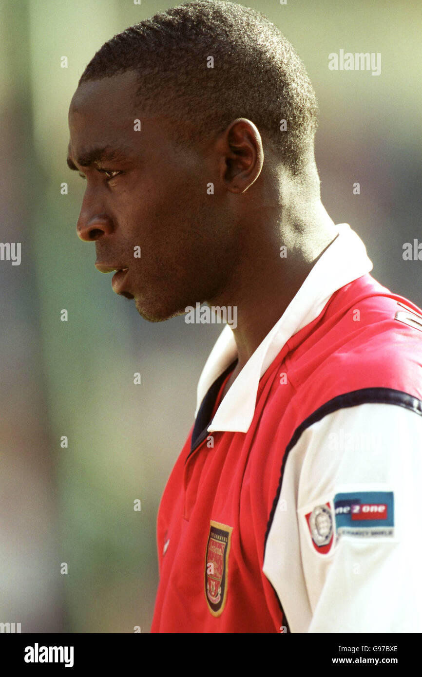 Manchester United's Andy Cole walks off wearing an Arsenal shirt after his team's defeat Stock Photo