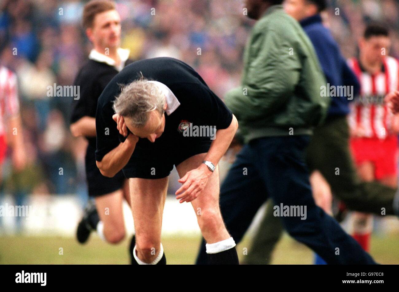 ENGLISH SOCCER. REFEREE ROGER WISEMAN runs off the pitch after being hit on the head by a fan
