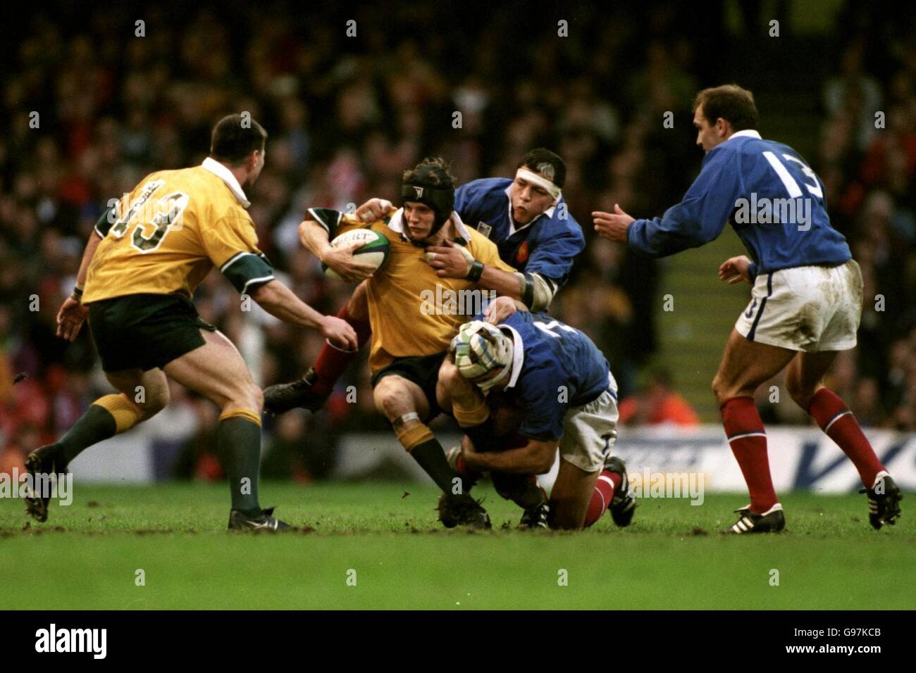 Australia's Stephen Larkham (second left) is brought down by France's Olivier Magne (second right, bottom) and Abdelatif Benazzi (second right, top) Stock Photo