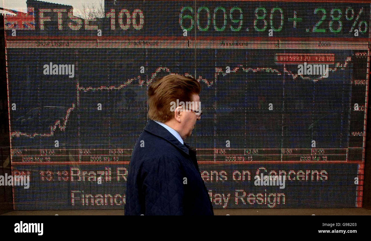 A commuter walks past an electronic display showing the FTSE index at the milestone of 6009.80, Friday March 17, 2006, which it hit today for the first time in five years. The Footsie, which rose 15.2 points to 6008.4 in the first minutes of trading, was last higher in March 2001 before the bursting of the dotcom bubble sent it spinning to a low of 3287 two years later. See PA Story CITY FTSE. PRESS ASSOCIATION Photo. Photo credit should read: Stefan Rousseau/PA. Stock Photo