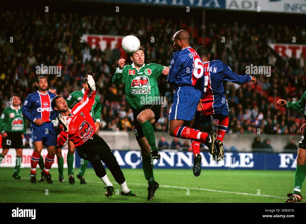 Paris St Germain's Godwin Okpara (right) heads for goal, as Sedan Ardennes's Luis Satorra (centre) challenges Stock Photo