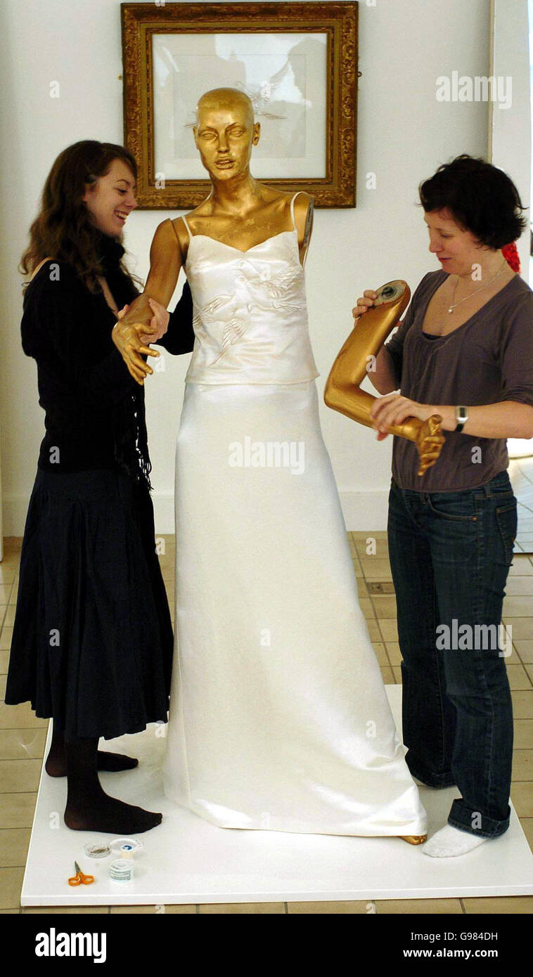 Fashion designers Helen Amy Murray, right, and Emma Lawler put the finishing touches to the 'Dress to Art' wedding gown, Wednesday 22nd March before the opening of an exhibition of eco-friendly fashion, in London. The wedding dress, designed to be recycled as art and day wear, is the centre point of the exhibition, Well Fashioned: Eco Style in the UK, at the Crafts Council Gallery until 4th June. See PA story CONSUMER Dress. PRESS ASSOCIATION PHOTO. Photo credit should read: Ian Nicholson/PA Stock Photo