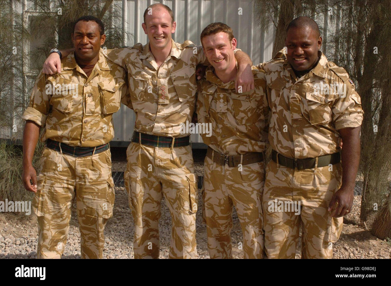 Members of the 1st Battalion Royal Scots triumphant rugby union team including team-captain, Captain Rob Muir (top, centre-left), from Edinburgh, Captain Kevin Gartside (middle, centre-right), from Belfast, Private Tuicaucau (left) and Private Tawakenou (right), both from Fiji, pose for a group photograph at Shaibah Logistics Base (SLB) near Basra, southern Iraq, Saturday March 18, 2006. The team recently defeated the Royal Welsh in the final of the Army Cup. See PA story DEFENCE Iraq. PRESS ASSOCIATION Photo. Photo credit should read : Johnny Green/PA. Stock Photo