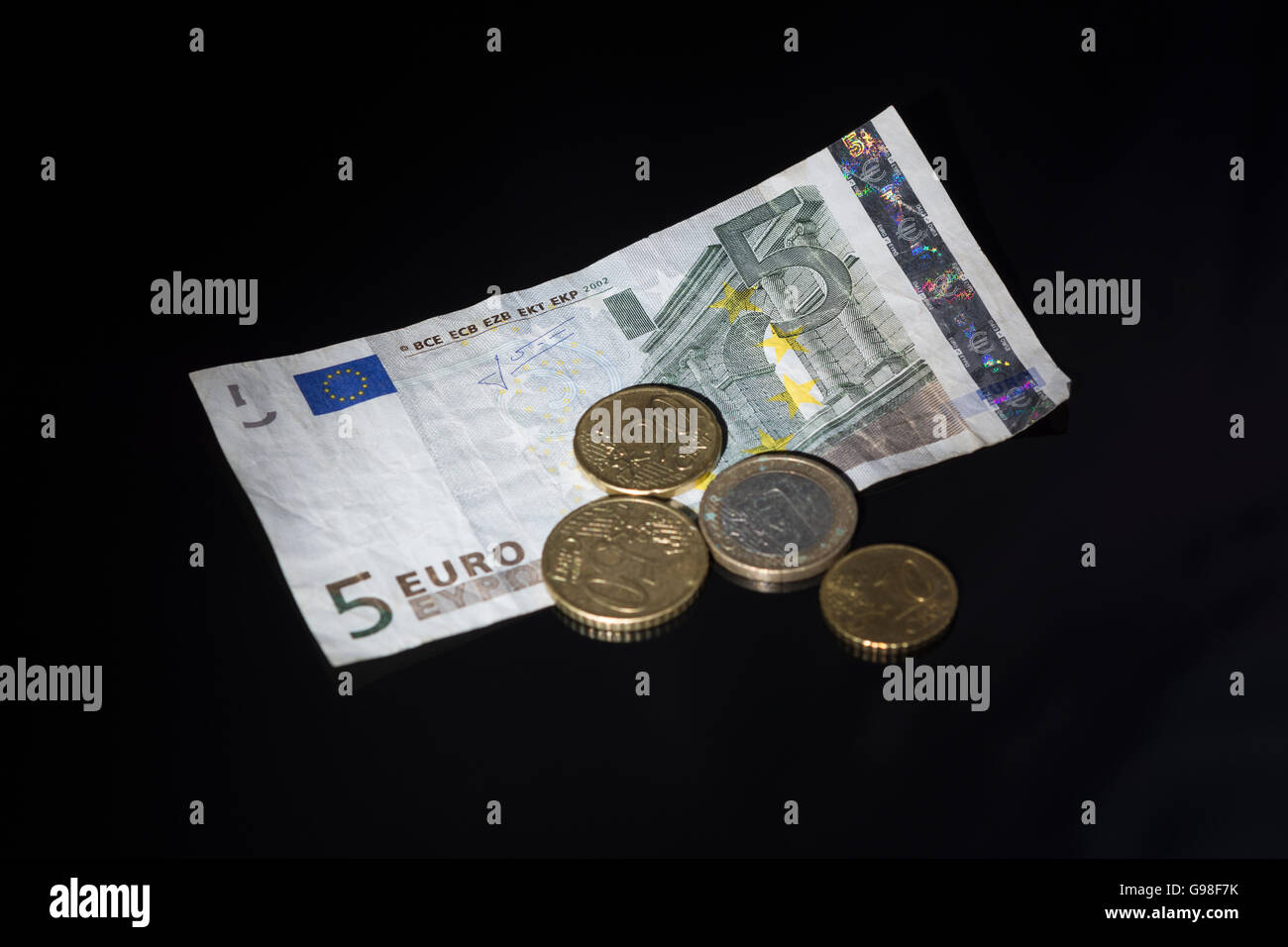 Concept of Euro zone, single market represented by a bundle of 5 Euro banknote and coins. Stock Photo
