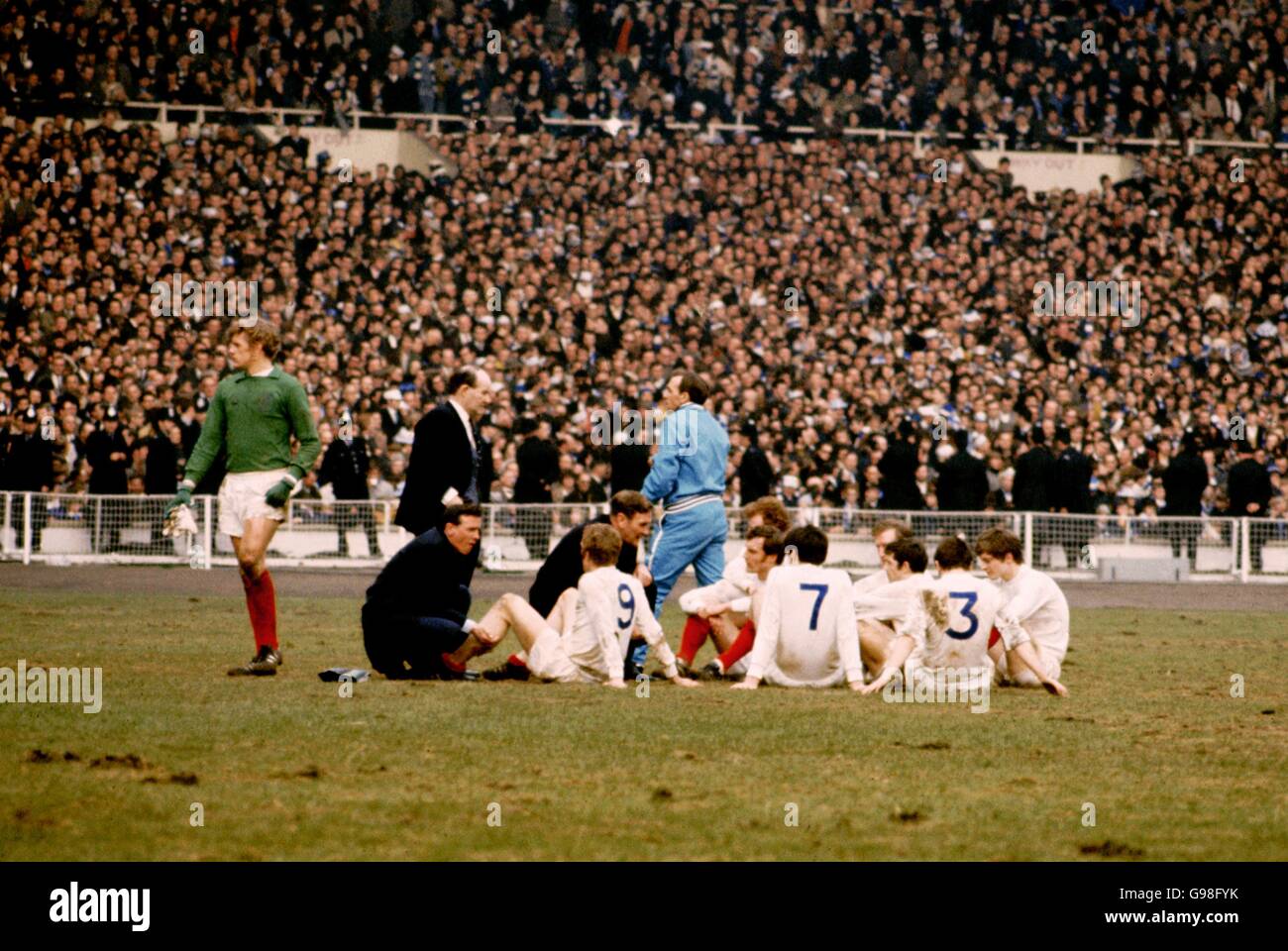 Leeds United goalkeeper Gary Sprake (green shirt) stands alone as the rest of the Leeds team Mick Jones, Billy Bremner, Paul Madeley, Peter Lorimer, Jack Charlton, Johnny Giles, Terry Cooper, Allan Clarke take instructions from Manager Don Revie as trainer Les Cocker (blue tracksuit) looks away. Stock Photo