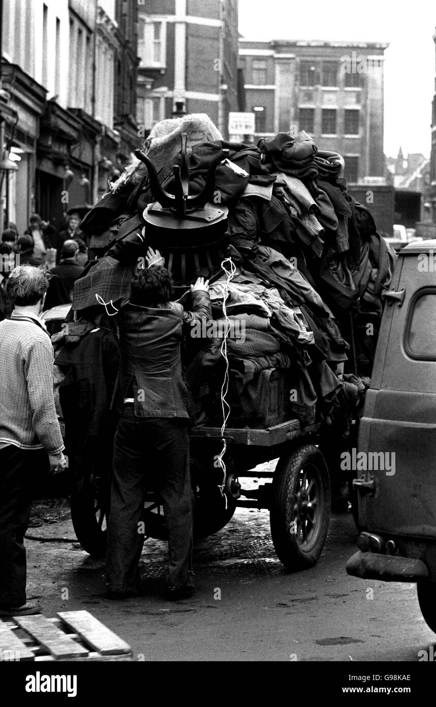 A Totter loads his horse-drawn cart with old garments at the end of today's trading. It proved a field day for the totter when traders disposed of unwanted working garments. They, and the market move on to a new site at Nine Elms. Stock Photo