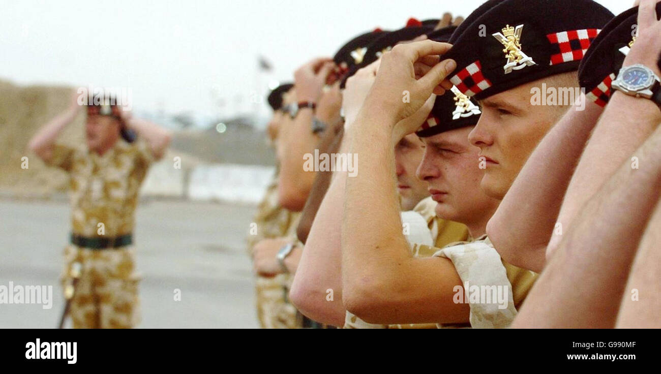 Members of the former Royal Scots regiment put on their new Glengarrys during a re-badgeing ceremony to mark the formation of the new Royal Regiment of Scotland (RRS) at the Shaibah logistic base in Basra, southern Iraq, Tuesday March 28, 2006. Ceremonies also took place today in Edinburgh, Cyprus and Belfast to mark the merger of six Scottish regiments to form the RRS. See PA story DEFENCE Regiments. PRESS ASSOCIATION photo. Photo credit should read: Danny Lawson/PA. Stock Photo