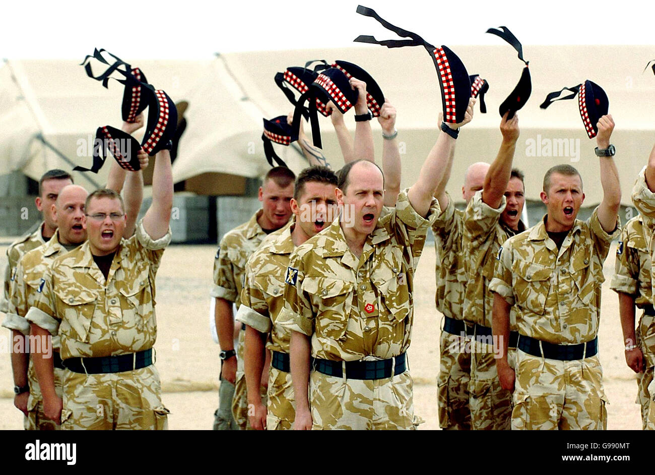 Members of the former Royal Scots regiment raise their new Glengarrys during a re-badgeing ceremony to mark the formation of the new Royal Regiment of Scotland (RRS) at the Shaibah logistic base in Basra, southern Iraq, Tuesday March 28, 2006. Ceremonies also took place today in Edinburgh, Cyprus and Belfast to mark the merger of six Scottish regiments to form the RRS. See PA story DEFENCE Regiments. PRESS ASSOCIATION photo. Photo credit should read: Danny Lawson/PA. Stock Photo