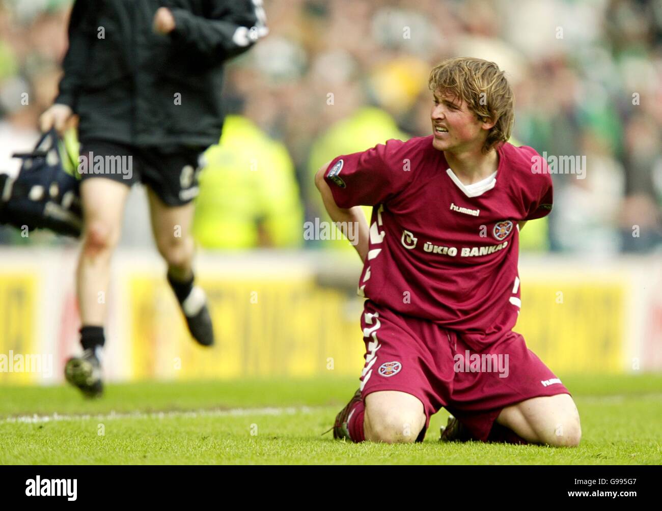 Soccer - Tennents Scottish Cup - Semi-Final - Hibernian v Heart of Midlothian - Hampden Park. Heart of Midlothian's Saulius Mikoliunas after being stamped on by Hibernian's Ivan Sproule Stock Photo