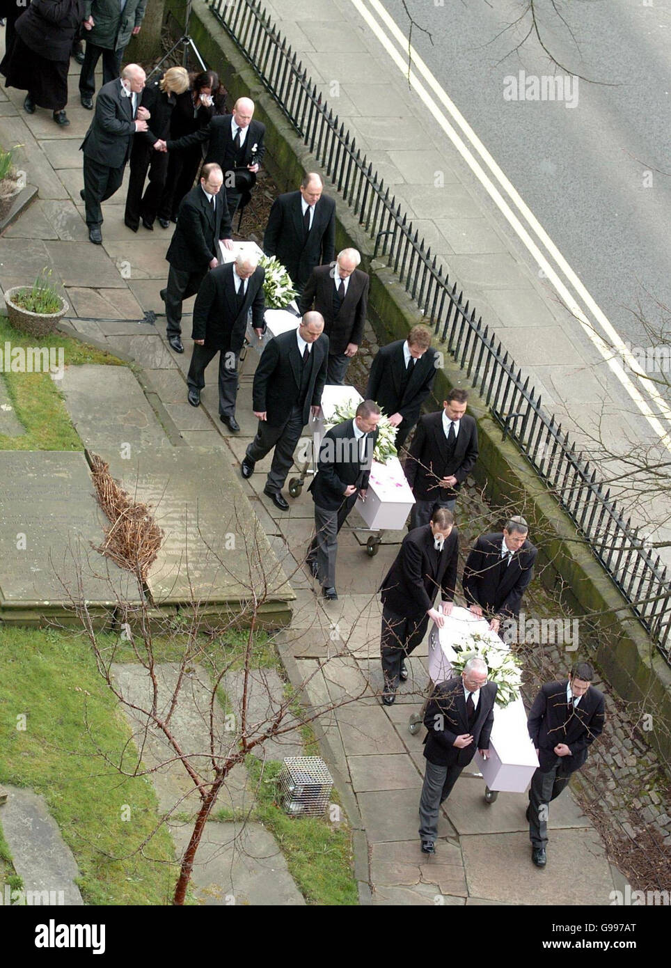 Mandy Carter (top left, blonde hair) follows the funeral cortege of her three children, Samantha, Patricia and Marcus Carter, as it arrives at St. Edward's Church in Leek, Staffordshire, Thursday April 6, 2006. The siblings died in an alleged arson attack at their semi-detached house in Hillside Road, Cheddleton, on March 9, with their mother's partner Roderick Hine. See PA story FUNERAL Children. Stock Photo