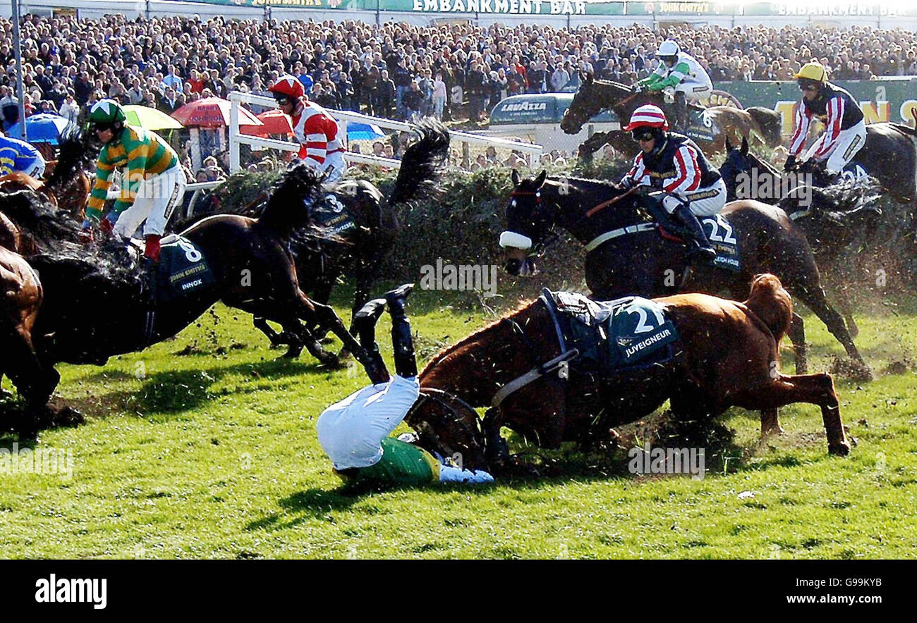 A bunch of fallers over the first fence in the John Smith's Grand National as Juveigneur and Mick Fitzgerald (foreground) join the early exits at Aintree racecourse. Stock Photo