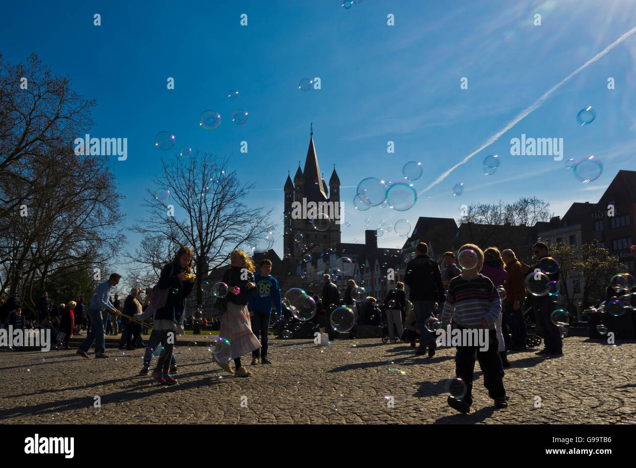 Cologne, children playing with bubbles in front of St. Martin chapel Stock Photo Alamy