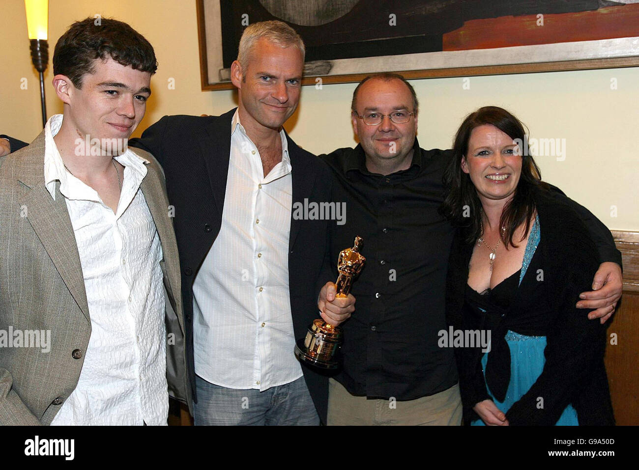 (L-r); Actor Ruaidhri Conroy, director Martin McDonagh (holding the Oscar), producer John McDonnell and co-producer Mary Mccarthy in the Clarence Hotel, Dublin, Friday April 7, 2006, for a party to reunite cast and crew members of the Oscar-winning short film Six Shooter. Mr McDonnell said tonight he was delighted to bring back Ireland's first Oscar for 14 years. The film, which is due to be released on DVD soon, stars Brendan Gleeson as a grieving widower who meets a talkative young man (Ruaidhri Conroy) on an Iarnrod Eireann train. See PA story SHOWBIZ Oscar Ireland. Stock Photo