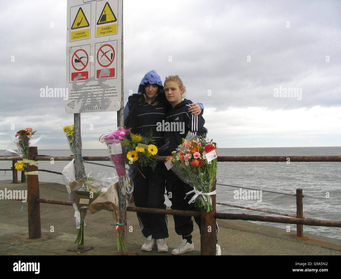 Zoe Boyle (left), 16, and Melissa Holtan, 15, at Hendon Beach in Sunderland, where 13-year-old Mark Langton was swept to his death by a wave while playing with friends on Monday afternoon. Picture date: Tuesday April 11, 2006. The youngster was caught by a wave and quickly carried 200 yards into deeper water where he was battered against rocks off the shore. He was recovered from the sea and taken to hospital, but later died. See PA story SEA Death. Photo credit should read: Paul Watson / PA. Stock Photo