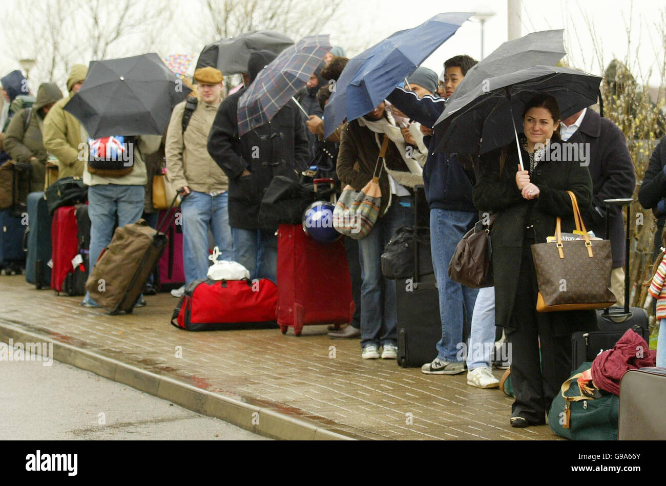 Eurostar passengers queue in pouring rain at Ashford International Station in Kent as Eurostar services were disrupted by a collapsed house in Ridley Road, Bromley, Kent which meant that holidaymakers and commuters faced long delays with the collapse causing severe disruption to Channel Tunnel and domestic rail services. Stock Photo