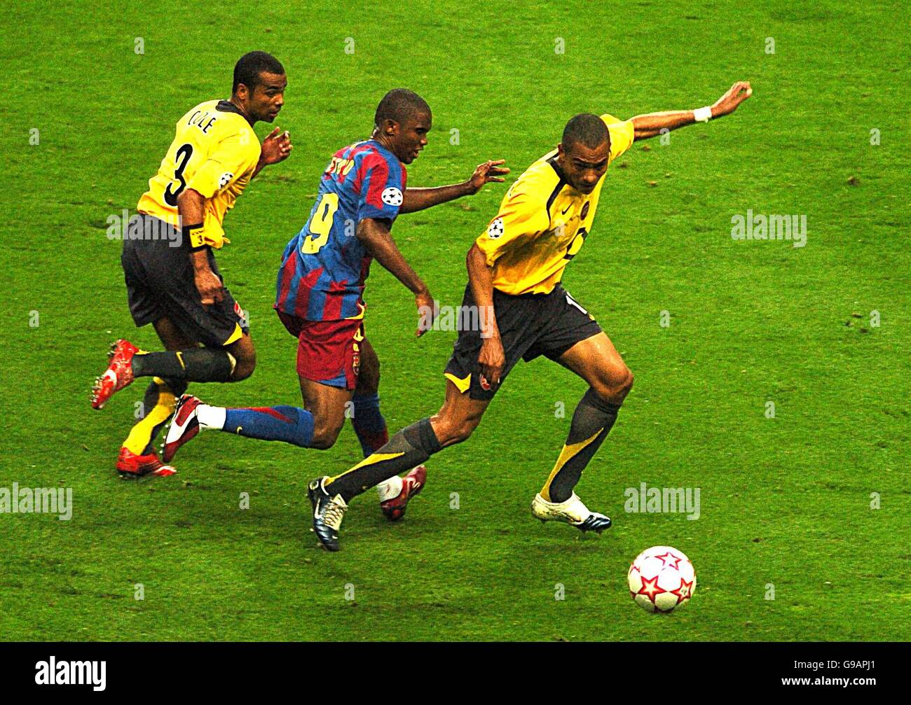 Arsenal's Ashley Cole (l) and Emmanuel Eboue (r) shield the ball from Barcelona's Samuel Eto'o (centre) Stock Photo
