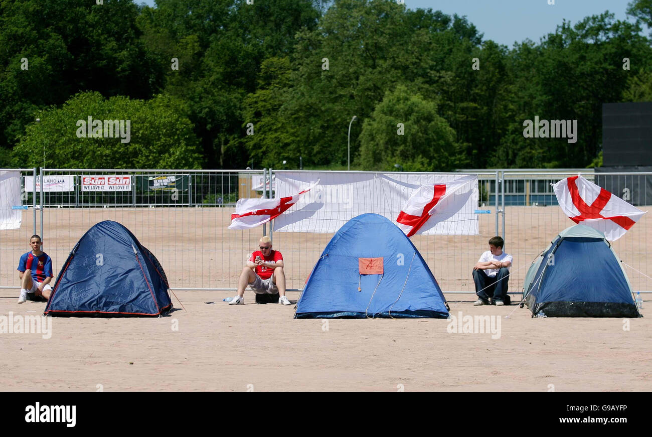 England supporters Anthony Barnes (left to right) Nick Thompson, and Matthew Deeks, relax after putting up theit tents at the England supporters camp in Archen, Germany, ahead of the start England's World Cup Campaign against Paraguay on Saturday in Frankfurt. . Stock Photo