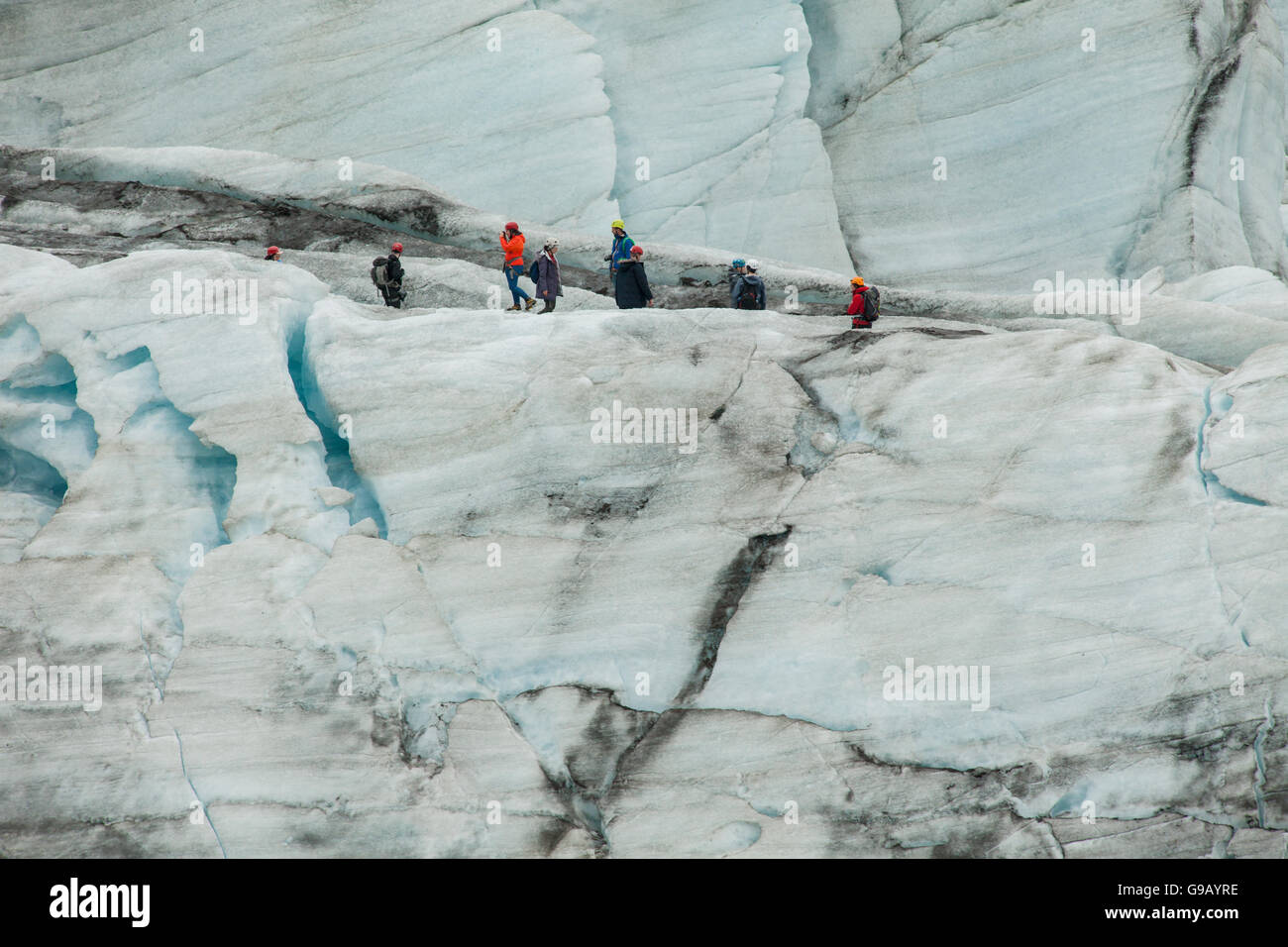 People walking on an Icelandic glacier. Stock Photo