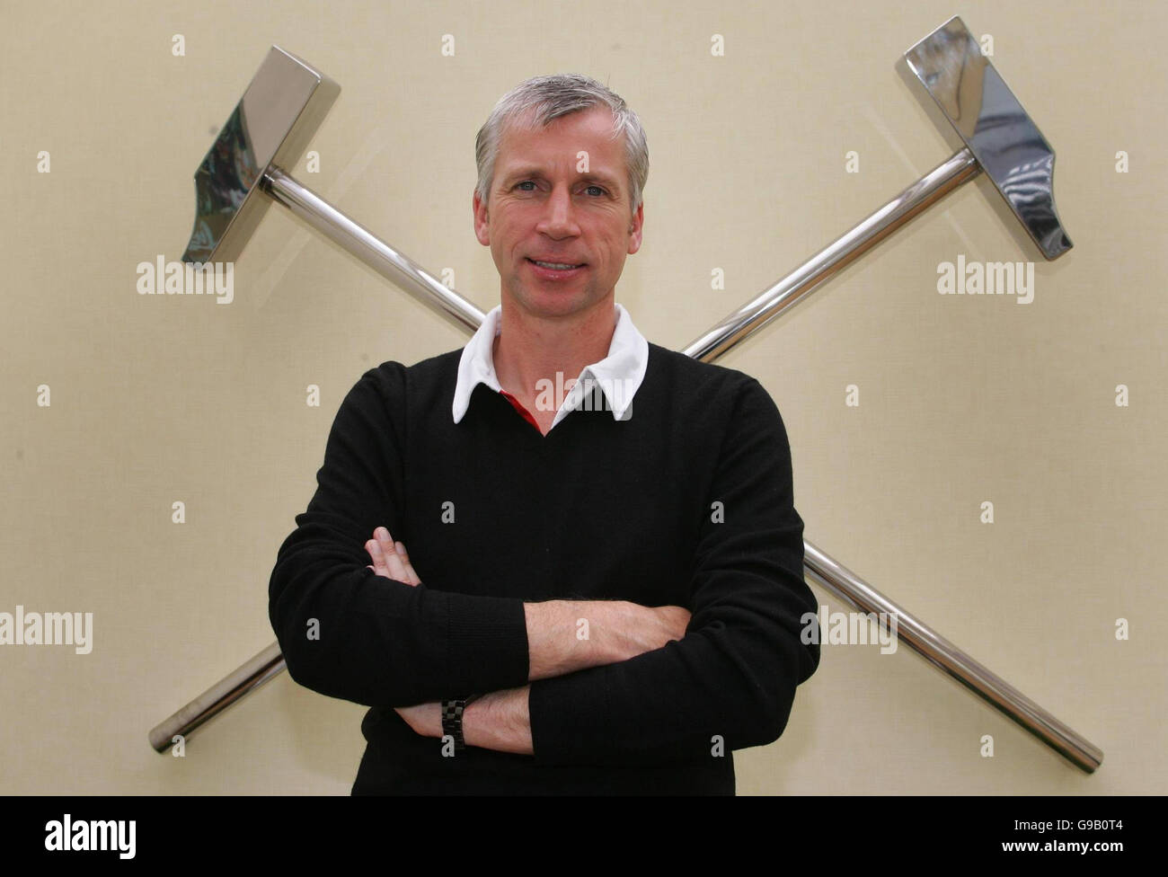 SOCCER West Ham. West Ham United manager Alan Pardew stands by the Club crest at the Chadwell Heath Training Ground, London. Stock Photo