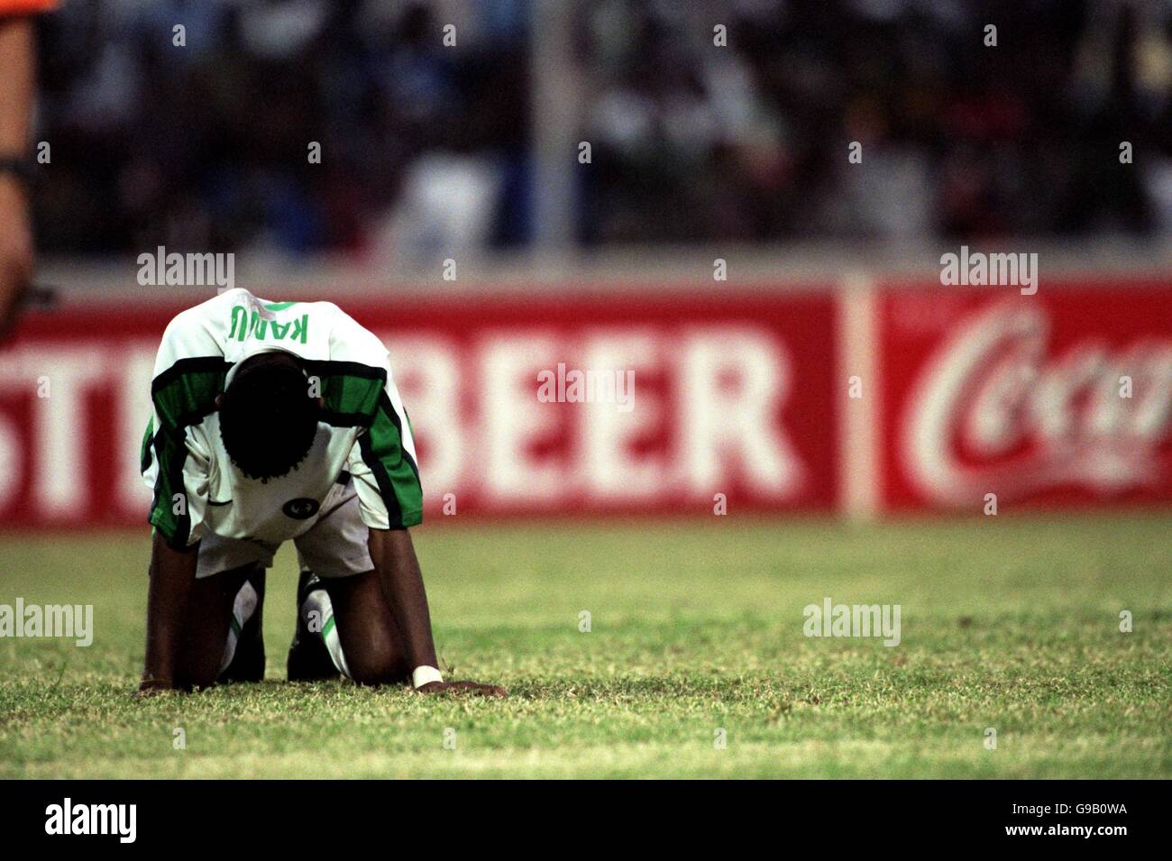 Nwankwo Kanu of Nigeria sinks to his knees after missing his penalty kick during the penalty shoot-out that Cameroon won Stock Photo