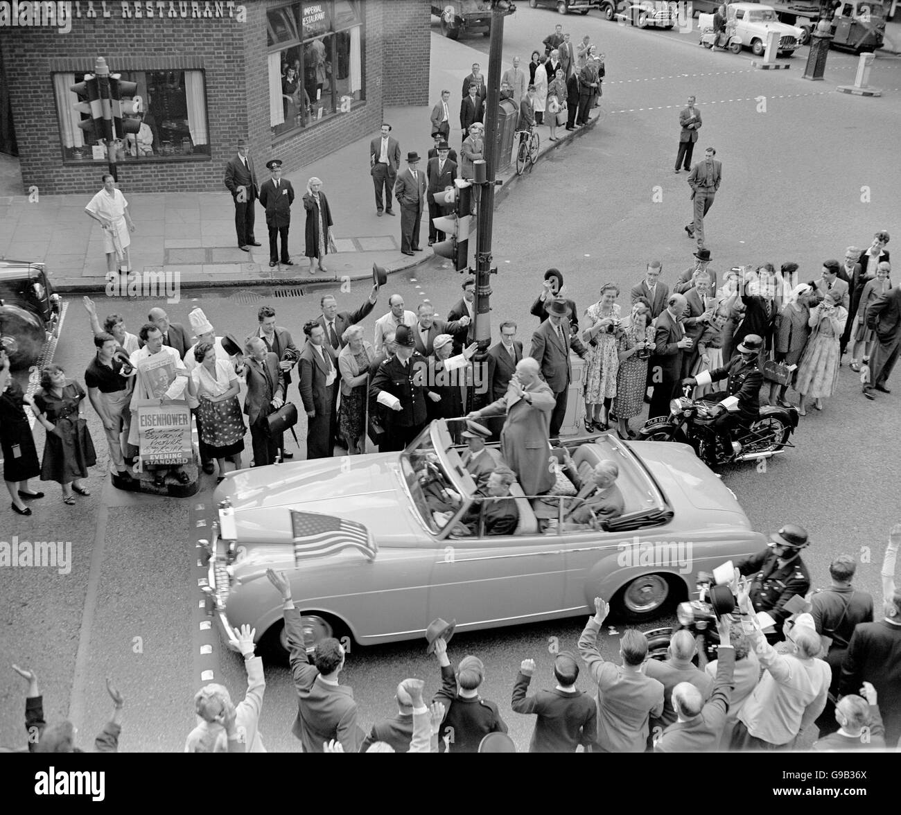US President Dwight Eisenhower (standing) waves to the crowds on Fleet Street as he is driven to St Paul's Cathedral with British Prime Minister Harold MacMillan (seated in back seat) Stock Photo