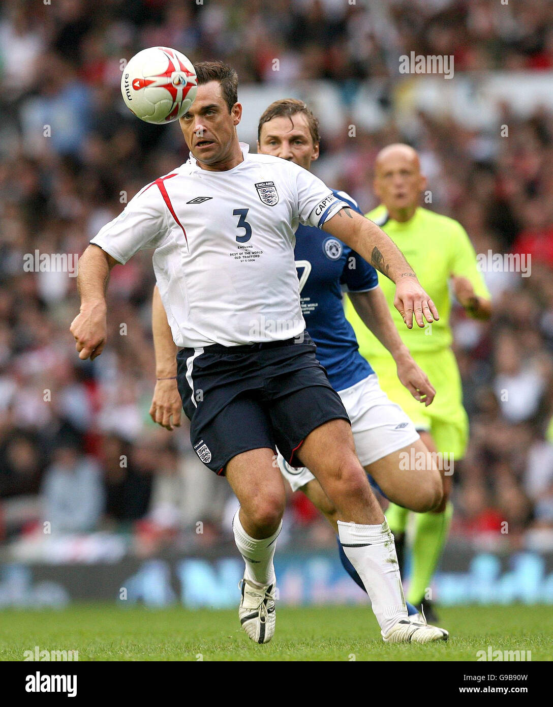 England team captain Robbie Williams (left) in action against the Rest of the World's Sergei Fedorov, during the UNICEF Soccer Aid charity football match, at Old Trafford, Manchester. Stock Photo