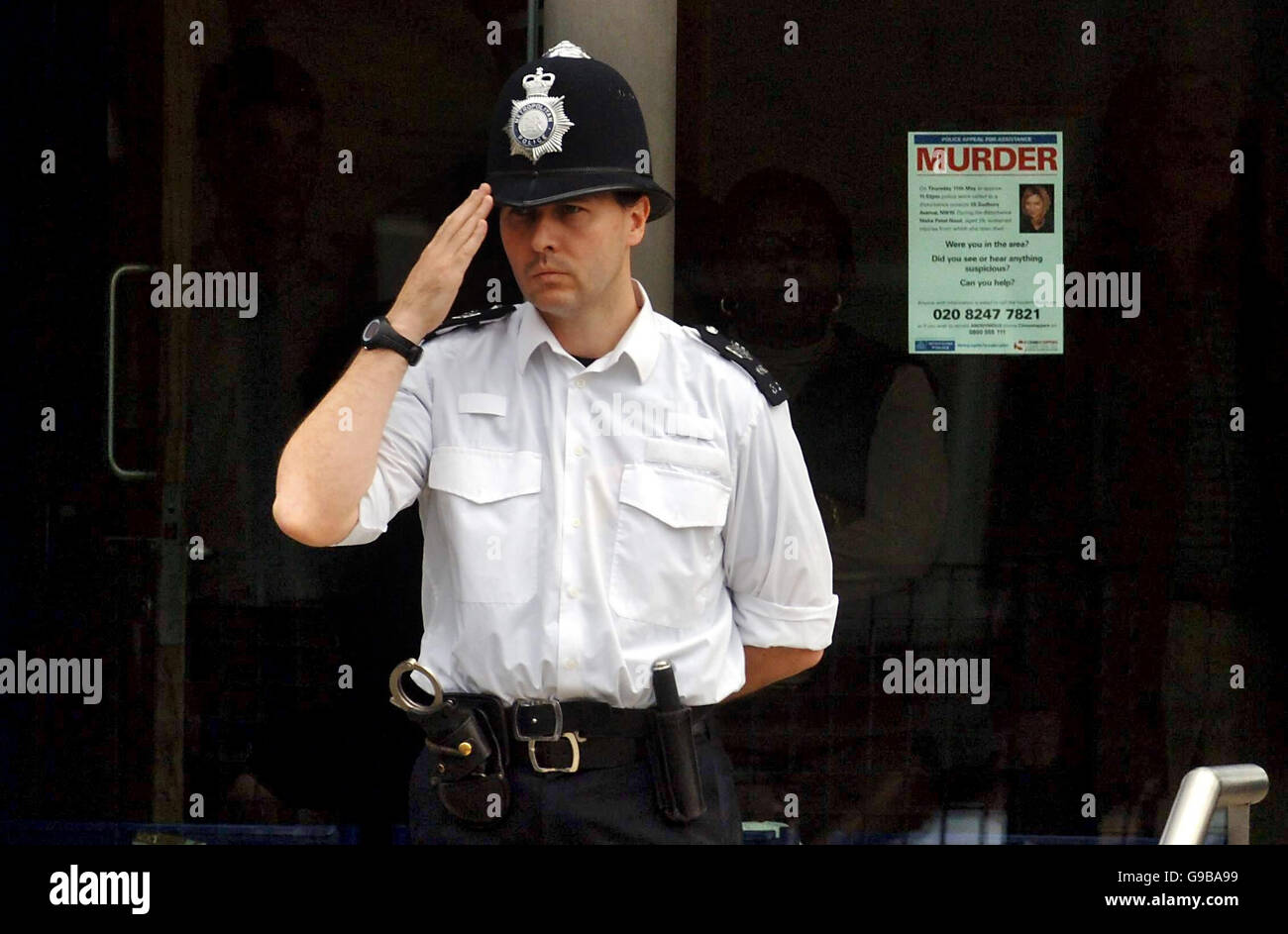 A police officer salutes the the funeral procession of murdered Special