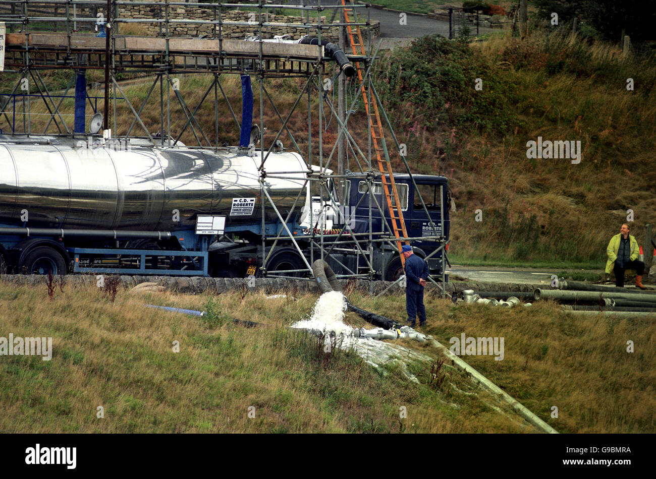 A contractor watches as water gushes from a pipe as Yorkshire Water's latest drought relief scheme gets off to a disasterous start. Pipes used for pumping water from the Booth Wood Reservoir to the centre of Halifax burst. Stock Photo