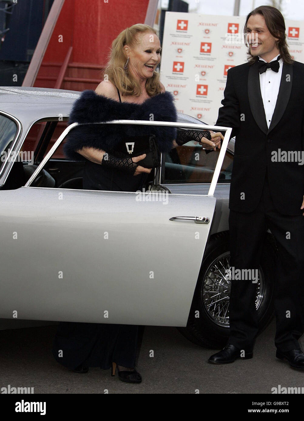 Ursula Andress is helped from car from son Dimitri Hamlin after arriving in the original James Bond Aston Martin DB5 from 'Goldfinger' at the Royal Yacht Britannia in Edinburgh to celebrate her Birthday. The occasion also marks the opnening of the Swiss Consulate General in Edinburgh. Stock Photo