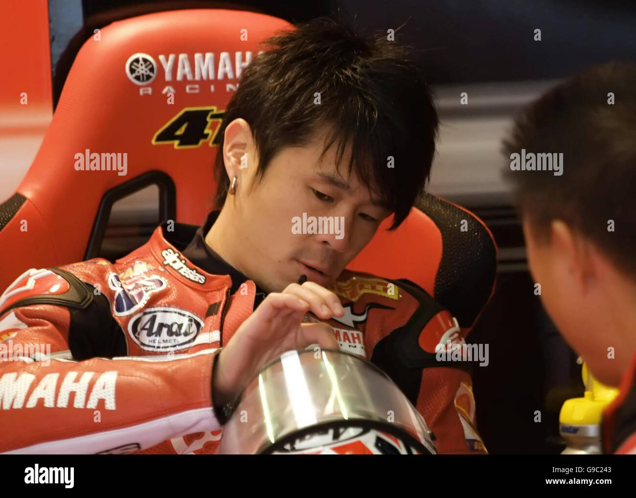 Japan's Noriyuki Haga talks to a Yamaha mechanic in his pit garage