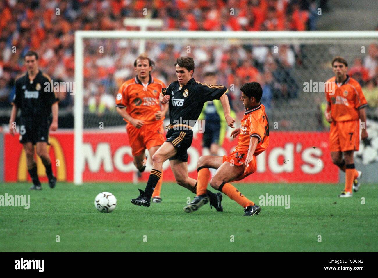 Real Madrid's Fernando Redondo strides over a challenge by Valencia's Gerard Stock Photo