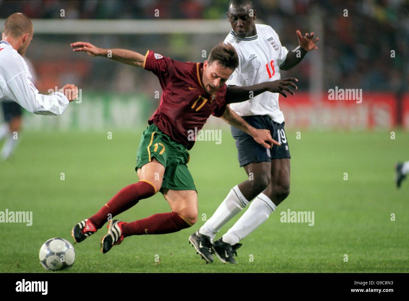 Portugal's Paulo Bento (l) goes down under pressure from England's Emile Heskey (r) Stock Photo
