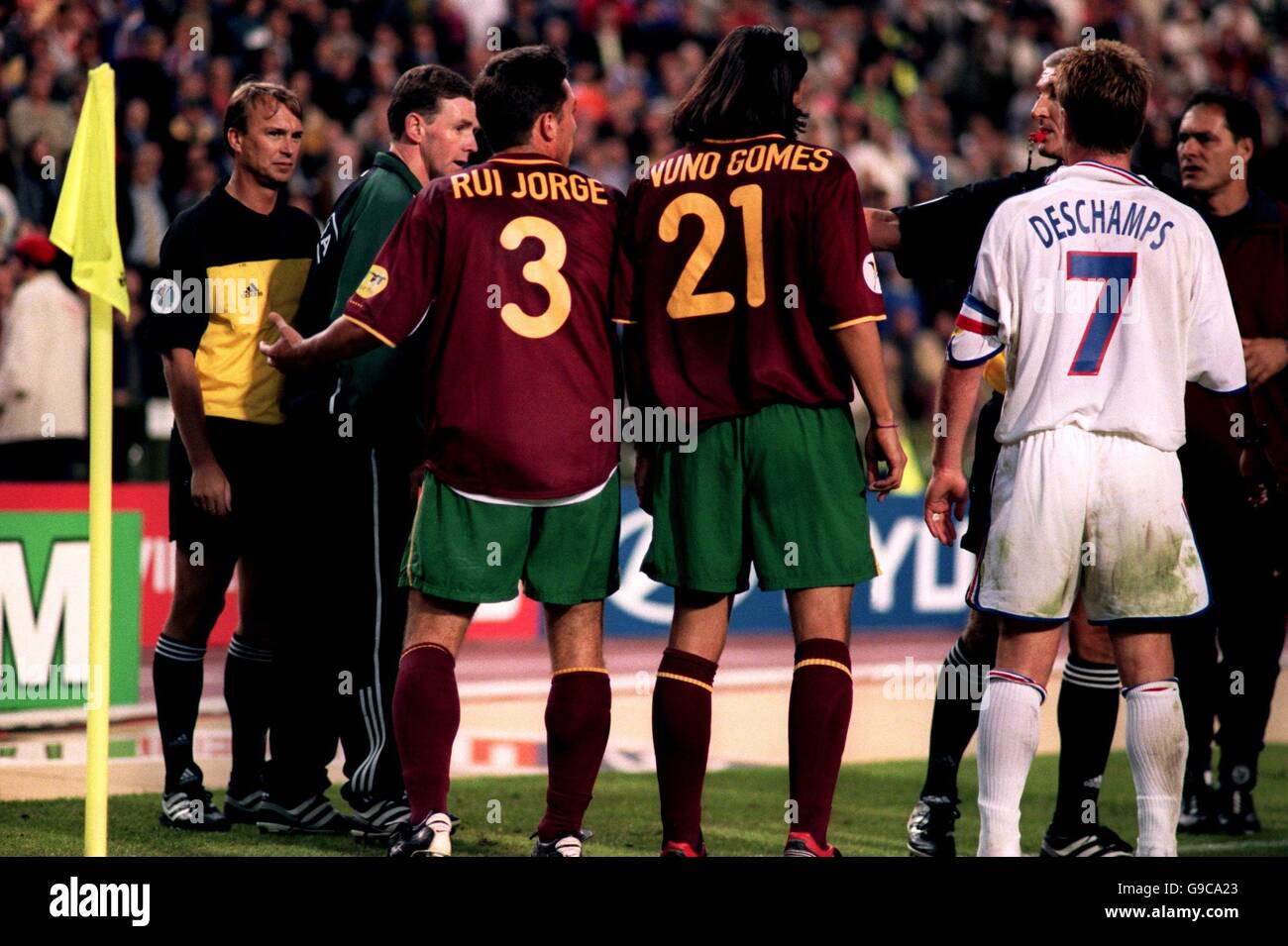 Linesman Igor Sramka (l) is protected from Portugal's Rui Jorge (no3) and Nuno Gomes (no21) by the fourth official Hugh Dallas (second left) and referee Gunter Benko (second right), after a penalty was awarded against Portugal in the 'golden goal' period of the match Stock Photo