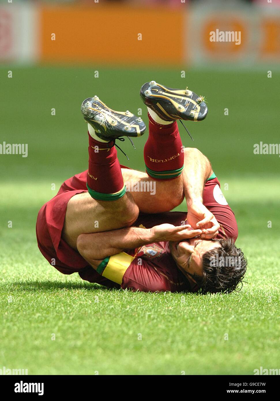 Luis Figo, Portugal sustains an injury from Iran's Hossein Kaabi (out of picture) Stock Photo