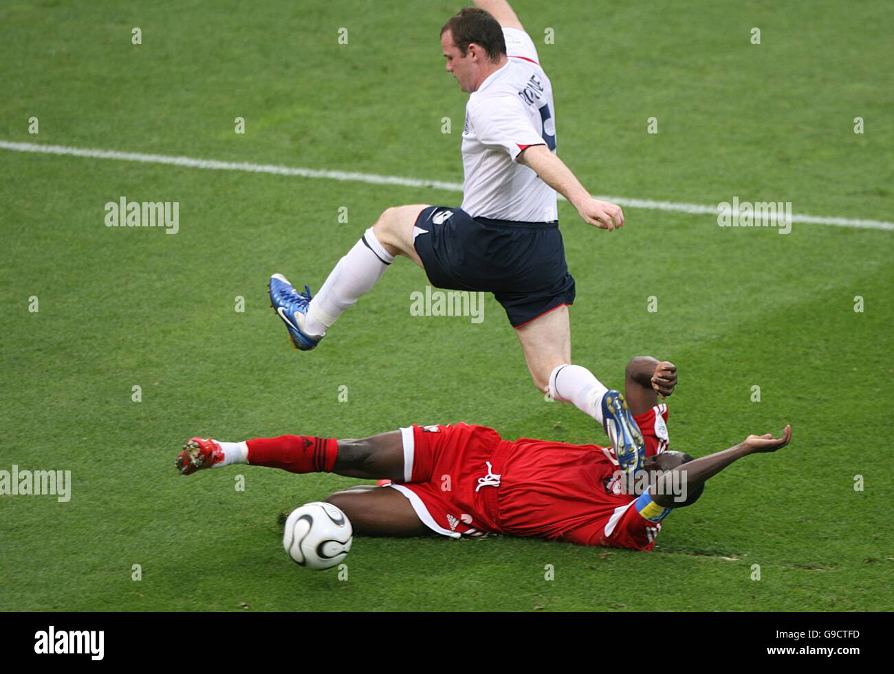 England's Wayne Rooney skips the challenge of Trinidad and Tobago's Dwight Yorke Stock Photo