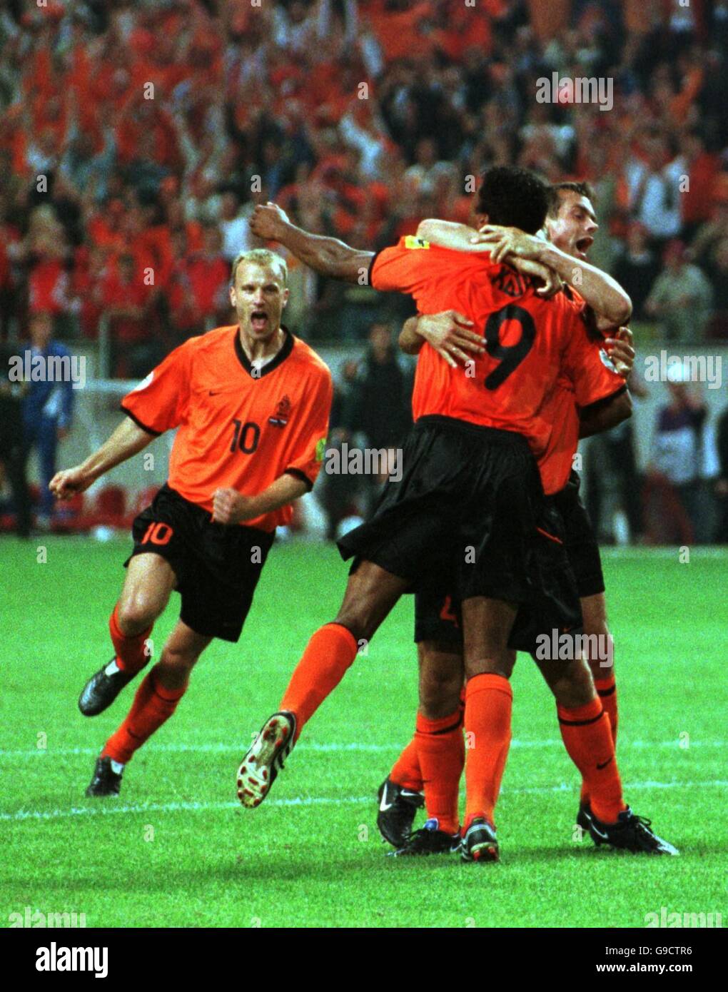 Holland's Frank De Boer (hidden) is mobbed by (l-r) Dennis Bergkamp, Patrick Kluivert and Phillip Cocu after scoring the winning goal from the penalty spot in the 89th minute Stock Photo