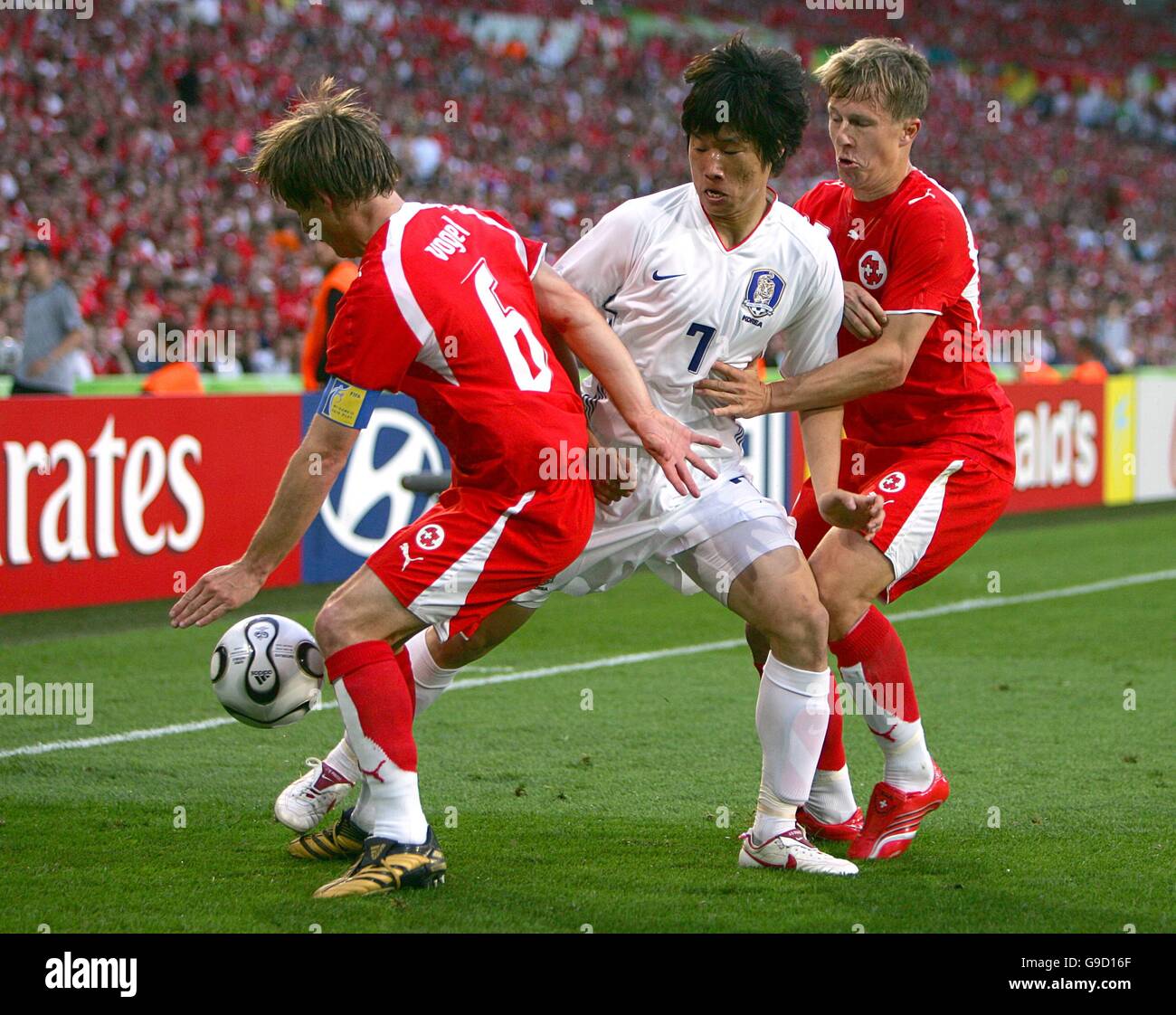 Soccer - 2006 FIFA World Cup Germany - Group G - Switzerland v South Korea - AWD Arena. South Korea's Ji-Sung Park (c) is put under pressure by Switzerland's Johann Vogel (l) and Christoph Spycher (r) Stock Photo