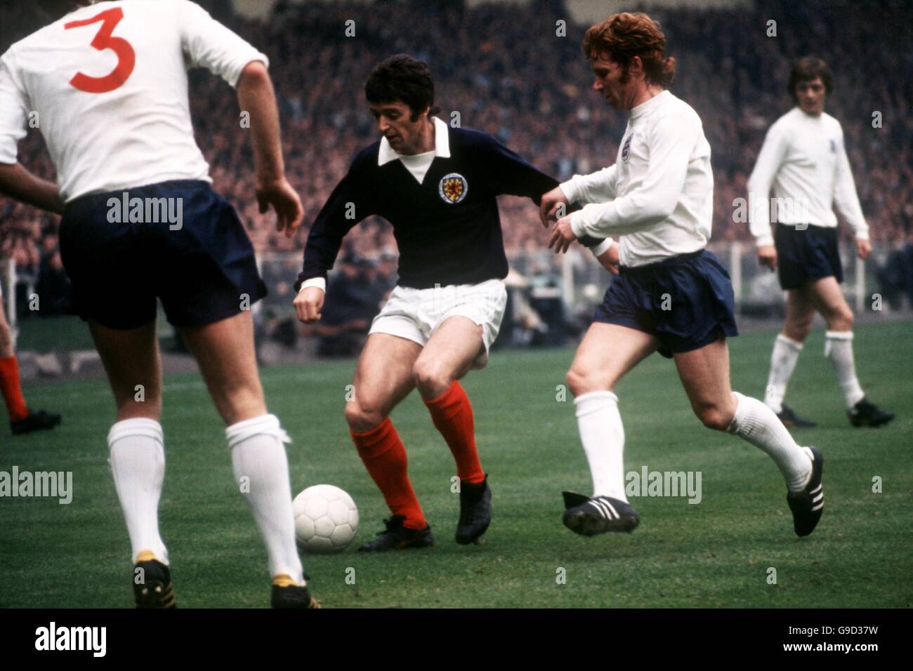 Scotland's Willie Morgan (c) is tracked by England's Emlyn Hughes (l) and Alan Ball (r) Stock Photo