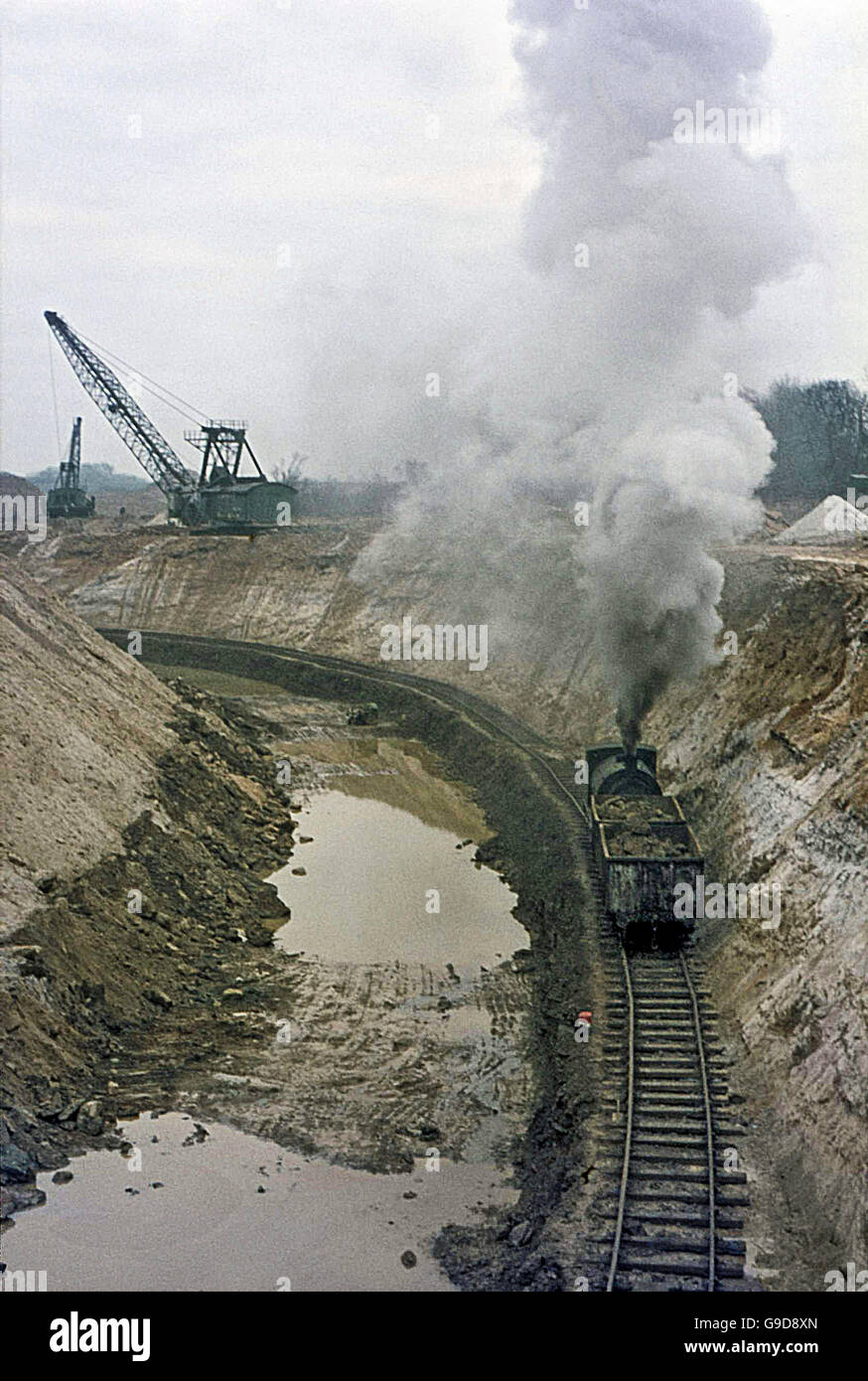 A loaded ironstone train heads through the gullet at Nassington past seams of outcropping silica white sand. Stock Photo