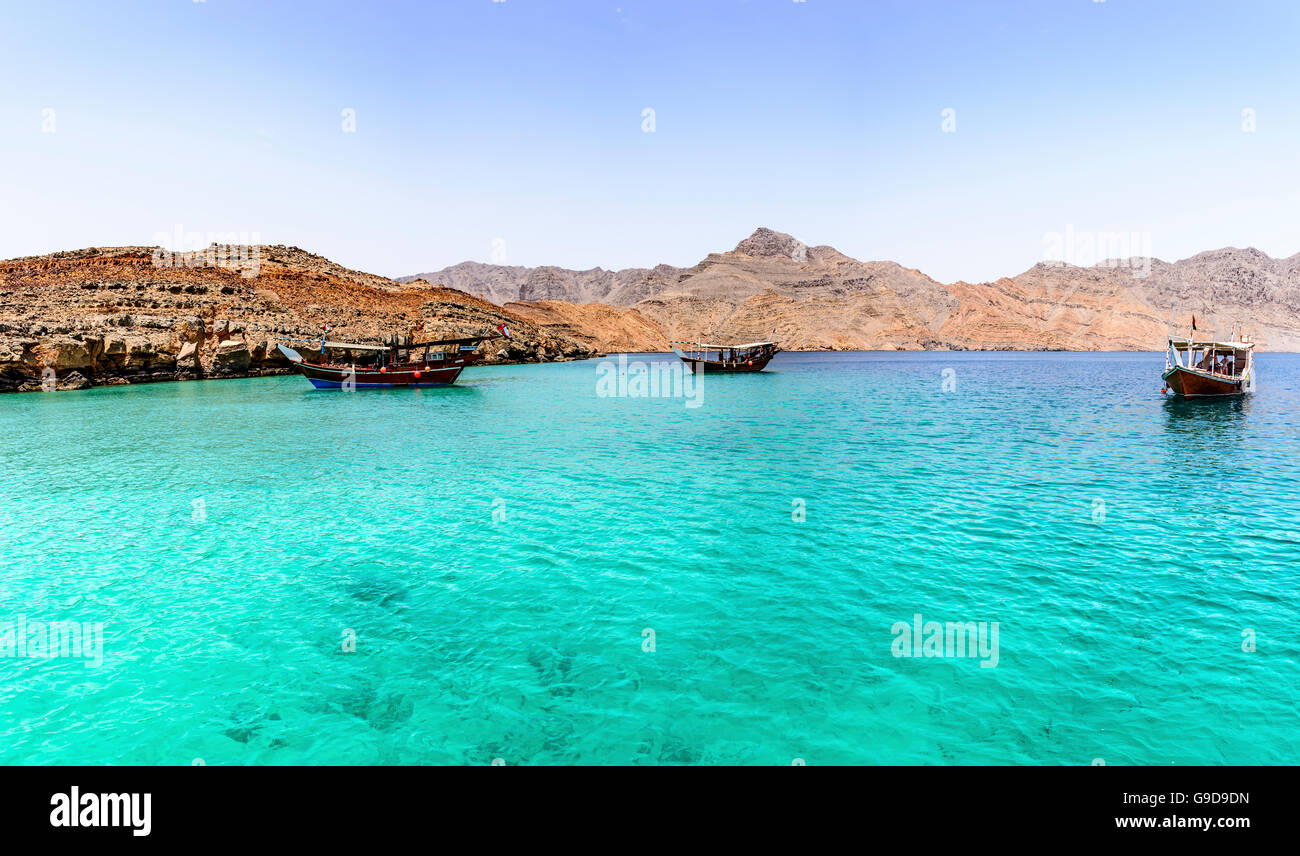 Traditional Arabic Dhows with tourists snorkeling in th wild fjord of Musandam peninsula, Sultanate of Oman Stock Photo